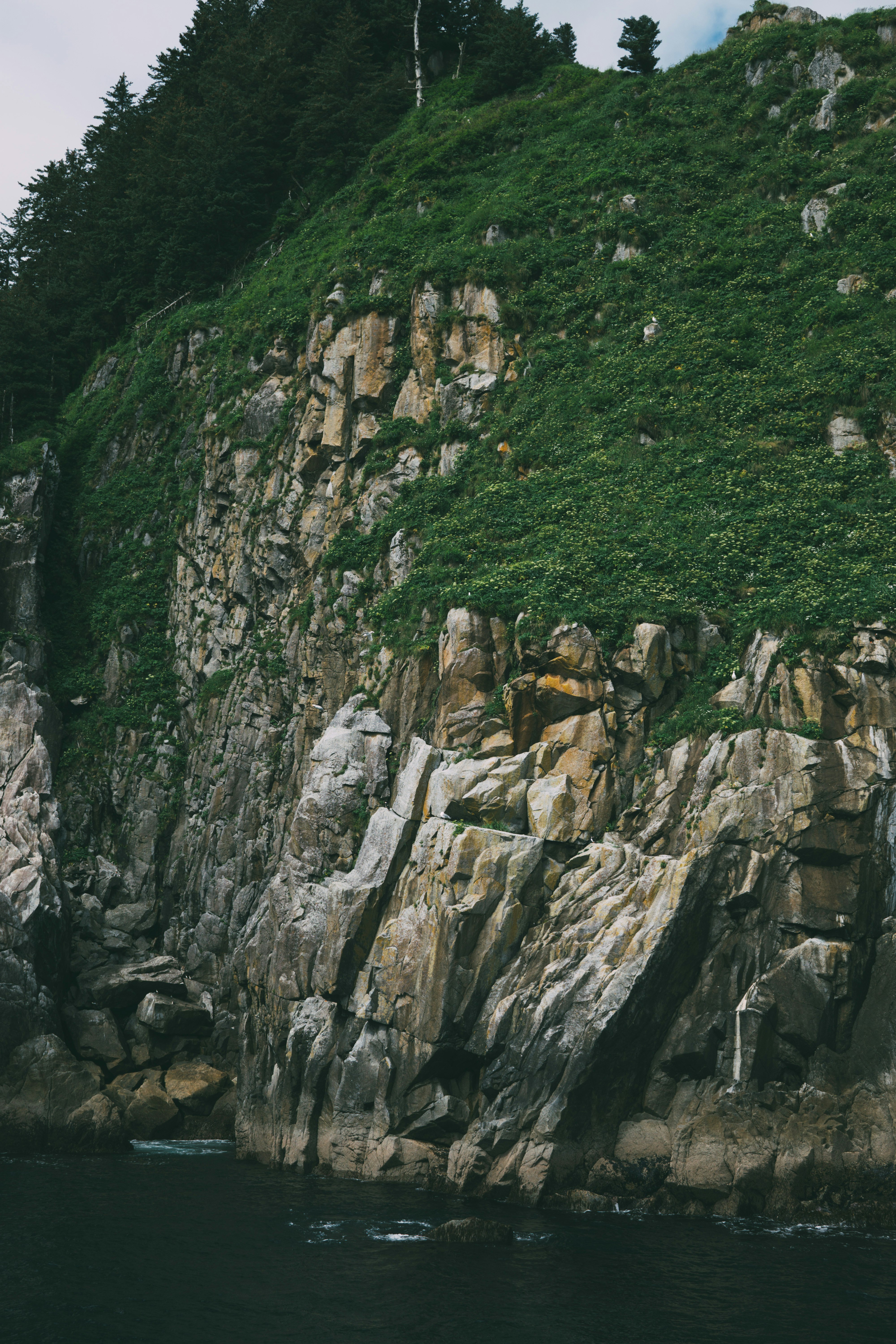 rock formation beside body of water during daytime